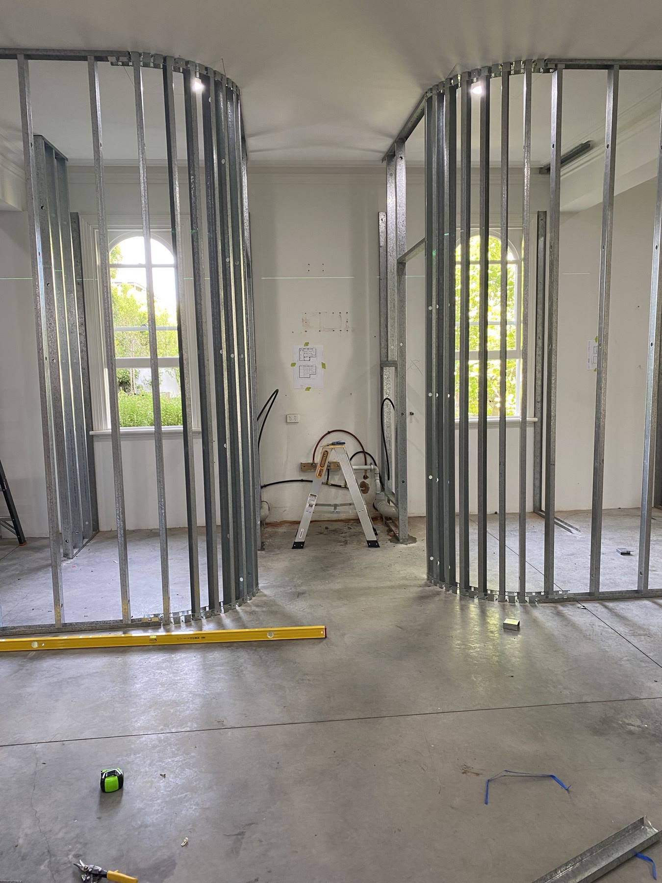 Curved steel framing establishing the wet-area room geometry