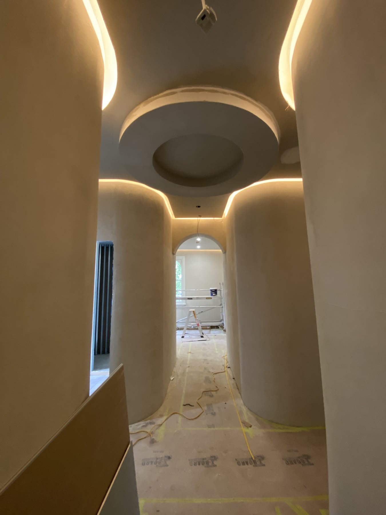 Illuminated curved hallway with herringbone floor detailing