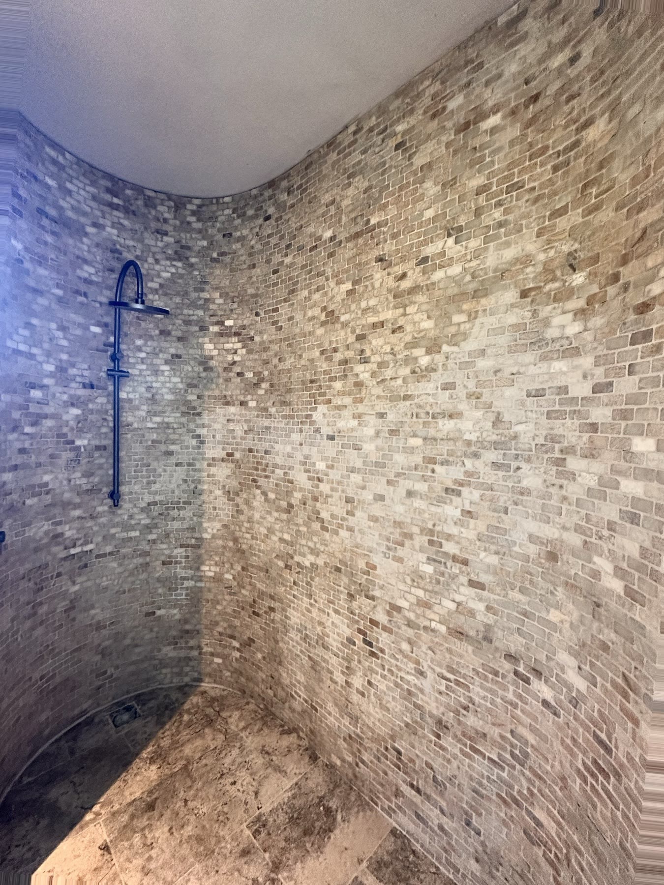 Curved stone mosaic shower detailing completed by Elya